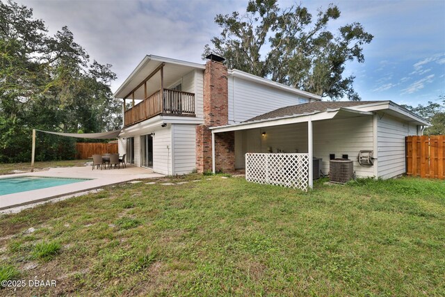 180 Willow Run, Ormond Beach, FL 32174 - rear view of property featuring a balcony, a patio area, a chimney, and central AC unit