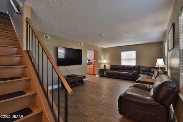 180 Willow Run, Ormond Beach, FL 32174 - living area featuring a textured ceiling, dark wood-style flooring, baseboards, and stairs