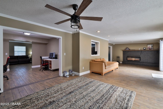 180 Willow Run, Ormond Beach, FL 32174 - living room with a textured ceiling, a desk, ceiling fan, wood-type flooring, and a brick fireplace