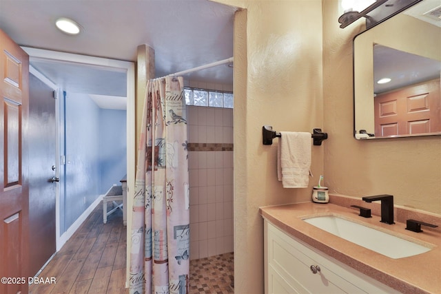 180 Willow Run, Ormond Beach, FL 32174 - bathroom with vanity, tiled shower, wood finished floors, recessed lighting, and baseboards