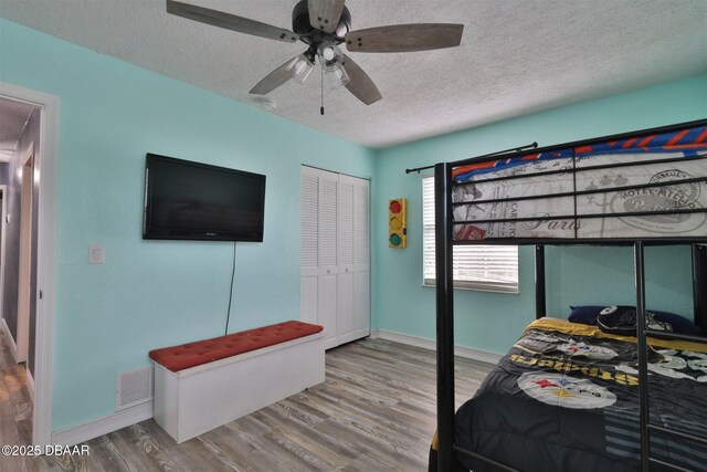 180 Willow Run, Ormond Beach, FL 32174 - bedroom featuring a textured ceiling, wood finished floors, baseboards, and a ceiling fan