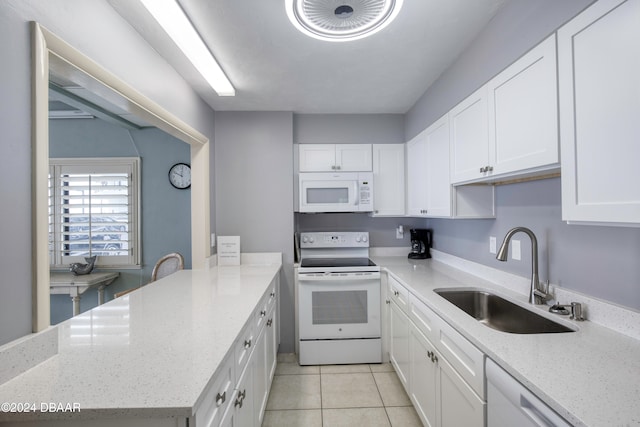 kitchen featuring white cabinetry, light stone countertops, sink, white appliances, and light tile patterned floors