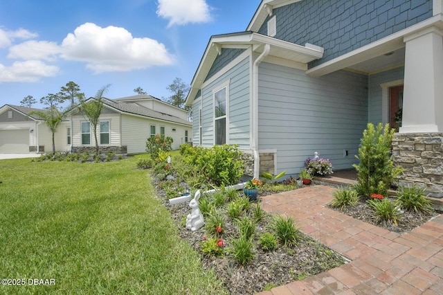 83 Reverie Dr N, Palm Coast, FL 32137 - view of side of home with a yard and stone siding