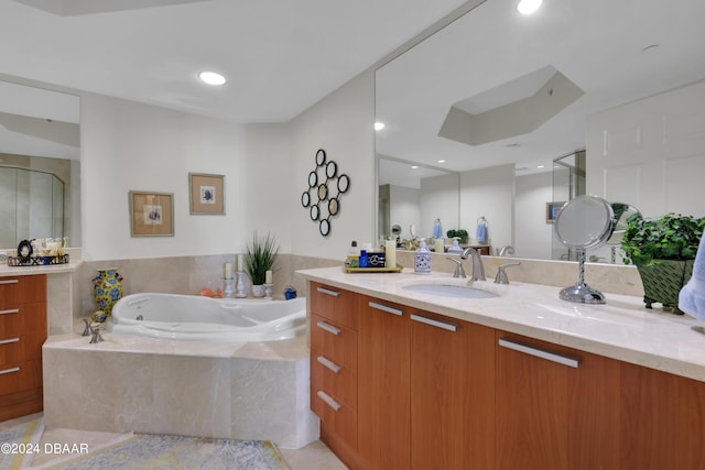 bathroom with vanity and a relaxing tiled tub