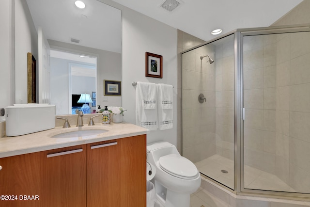 bathroom featuring vanity, tile patterned floors, toilet, and a shower with shower door