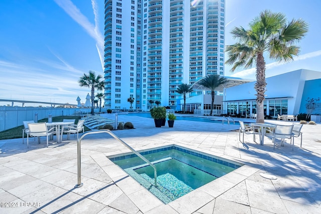 view of swimming pool featuring a patio and a hot tub