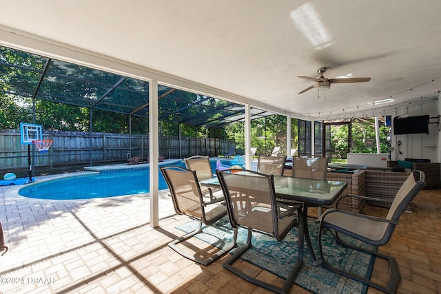 view of swimming pool featuring a patio, ceiling fan, and glass enclosure