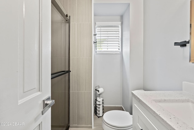 bathroom featuring walk in shower, vanity, and toilet