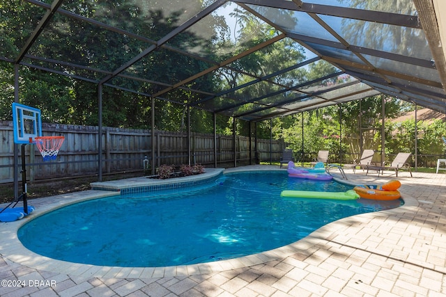 view of swimming pool featuring a patio area and a lanai