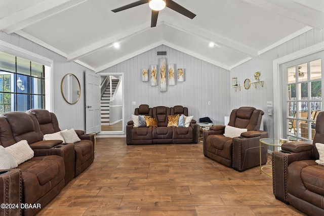 living room featuring lofted ceiling with beams, wood walls, wood-type flooring, and ceiling fan