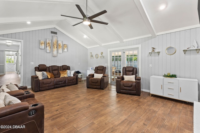 living room featuring vaulted ceiling with beams, wooden walls, hardwood / wood-style flooring, and ceiling fan