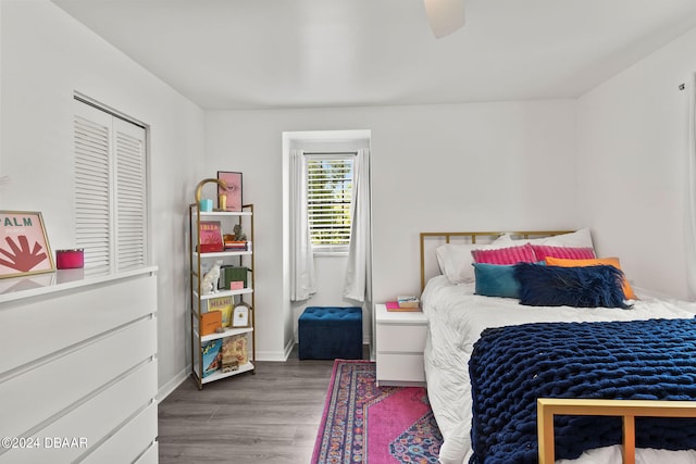 bedroom with dark hardwood / wood-style flooring, a closet, and ceiling fan