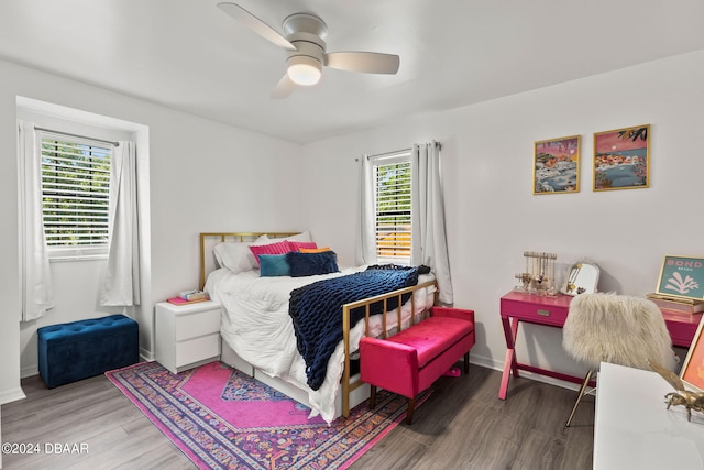 bedroom with dark wood-type flooring, multiple windows, and ceiling fan