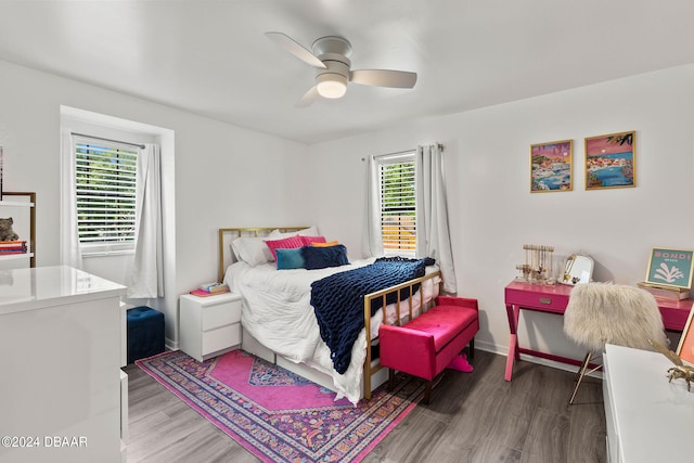 bedroom featuring dark wood-type flooring, ceiling fan, and multiple windows