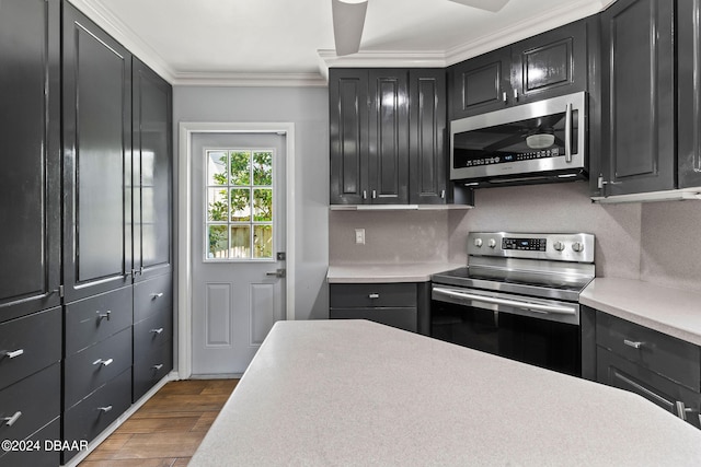 kitchen with dark wood-type flooring, backsplash, ornamental molding, and stainless steel appliances