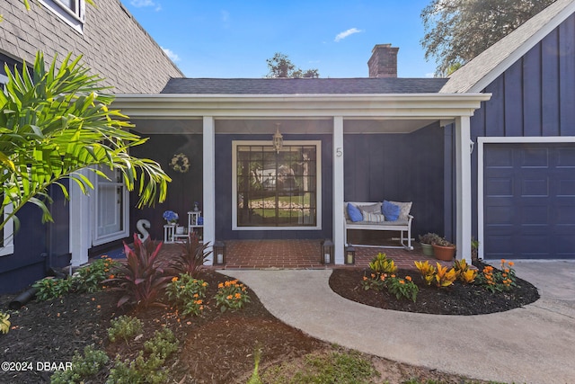 entrance to property featuring a garage and covered porch