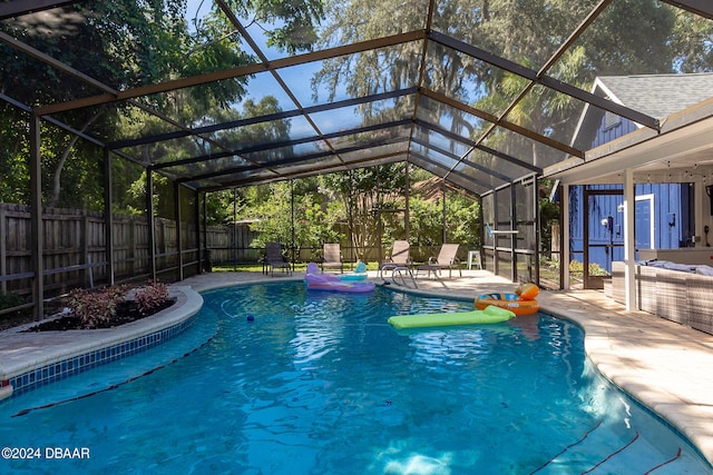 view of pool featuring glass enclosure and a patio area