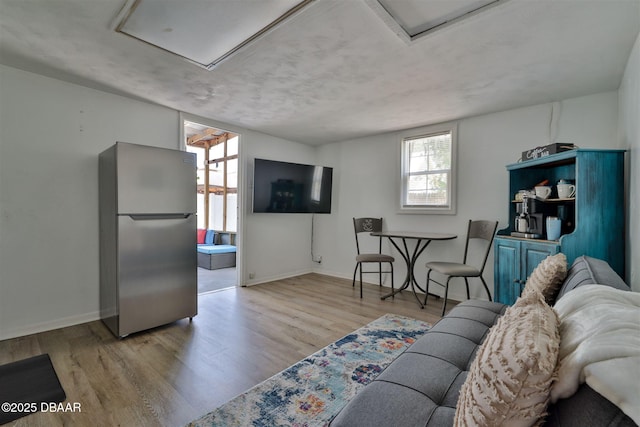 living room with attic access, wood finished floors, and baseboards