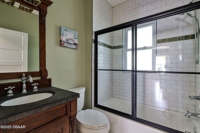 full bath with a wealth of natural light, enclosed tub / shower combo, toilet, and vanity