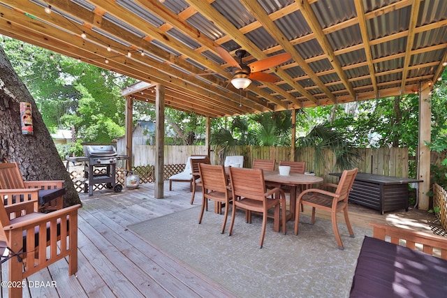 deck featuring ceiling fan, outdoor dining area, fence, and grilling area