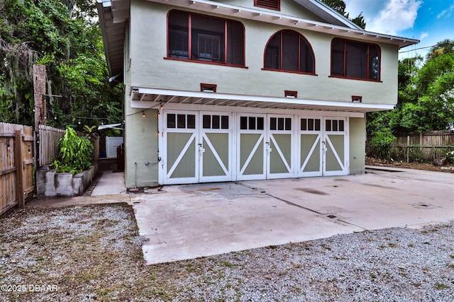 view of front of home featuring gravel driveway, a garage, and fence