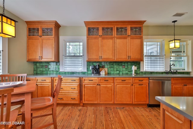 kitchen with stainless steel dishwasher, brown cabinetry, and visible vents