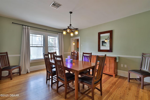 dining room featuring baseboards, visible vents, and light wood-type flooring