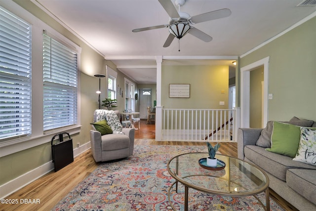 living room featuring baseboards, wood finished floors, ceiling fan, and ornamental molding