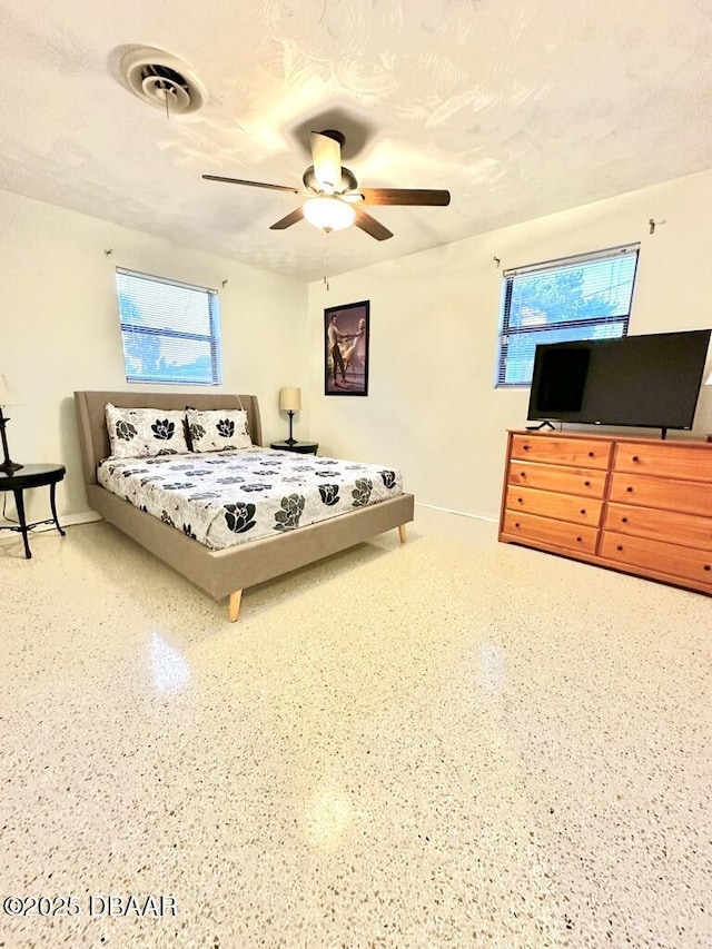 bedroom with visible vents, baseboards, multiple windows, and a ceiling fan