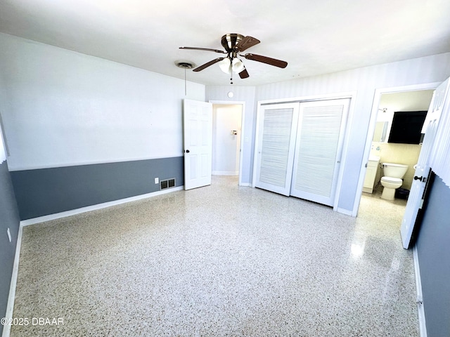 unfurnished bedroom with visible vents, a closet, baseboards, and speckled floor