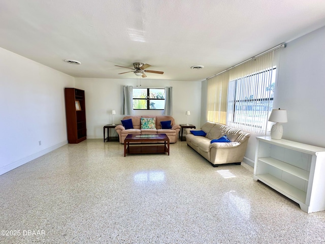 living room with visible vents, a ceiling fan, and speckled floor