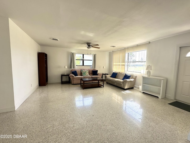 living room featuring ceiling fan, visible vents, speckled floor, and a healthy amount of sunlight