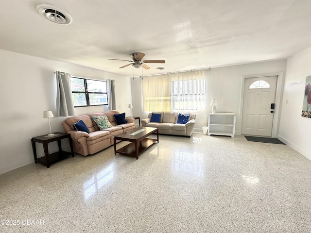 living room with visible vents, ceiling fan, and baseboards