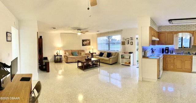 living area featuring light speckled floor and ceiling fan
