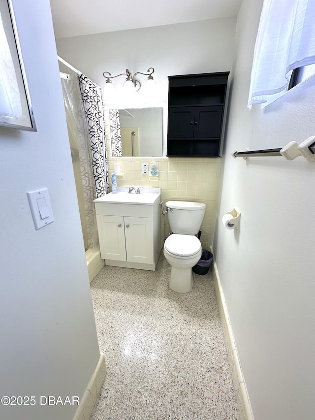bathroom with speckled floor, toilet, a shower with shower curtain, and vanity