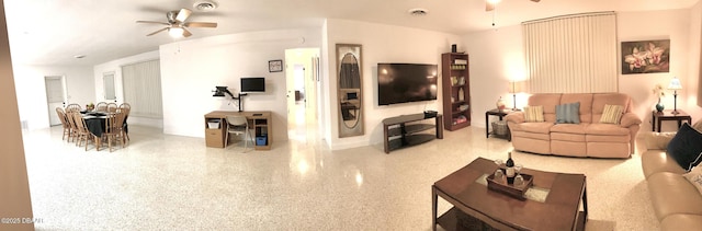 living room with visible vents, speckled floor, and ceiling fan