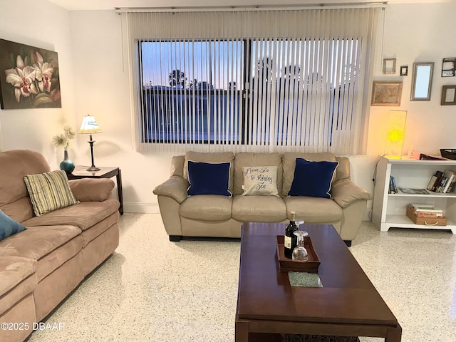 living room featuring baseboards and speckled floor