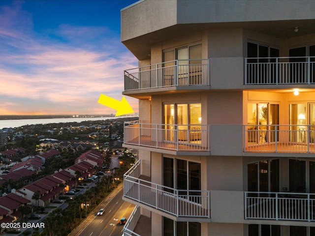 property at dusk featuring a water view