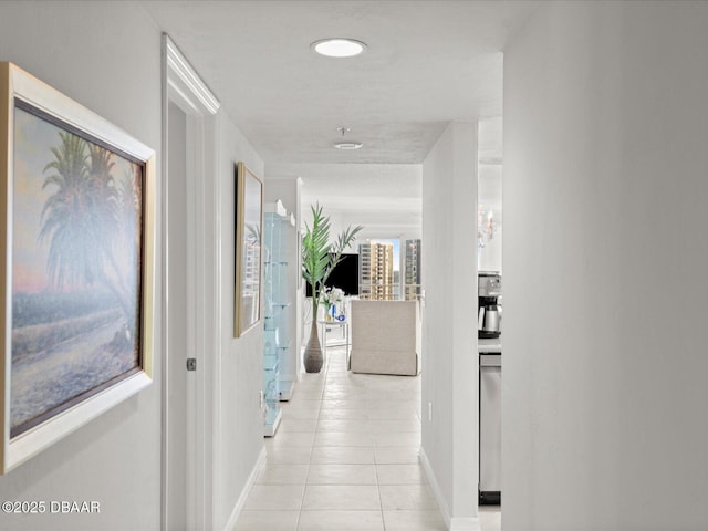 hall with baseboards and light tile patterned flooring