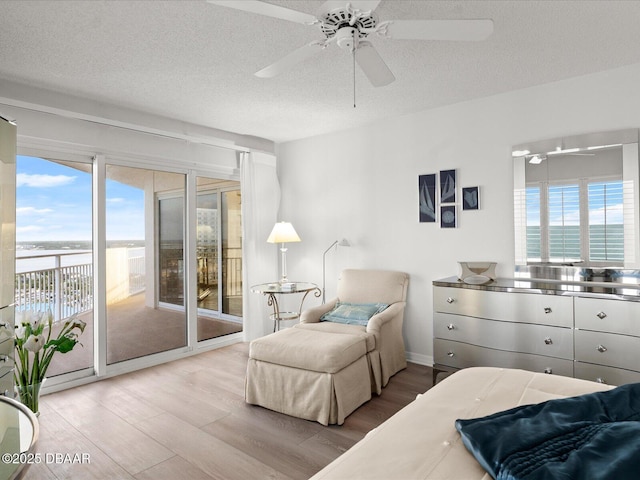 bedroom featuring access to outside, a textured ceiling, and wood finished floors