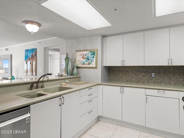 kitchen featuring a sink, dishwasher, light countertops, white cabinetry, and decorative backsplash