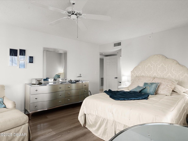 bedroom with ceiling fan, dark wood-style floors, and visible vents