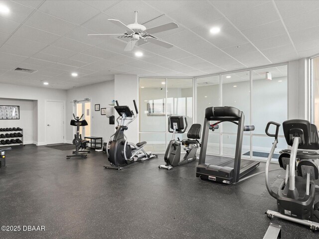 exercise room with a ceiling fan, visible vents, and a drop ceiling