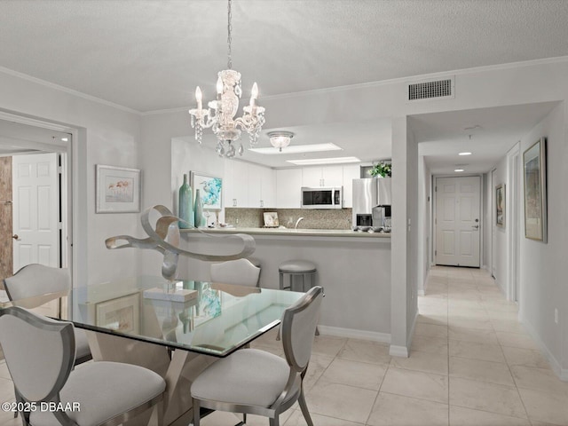 dining area with a chandelier, baseboards, visible vents, and ornamental molding