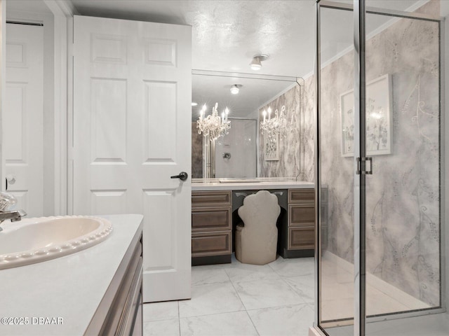 full bathroom with a notable chandelier, a shower stall, marble finish floor, and vanity