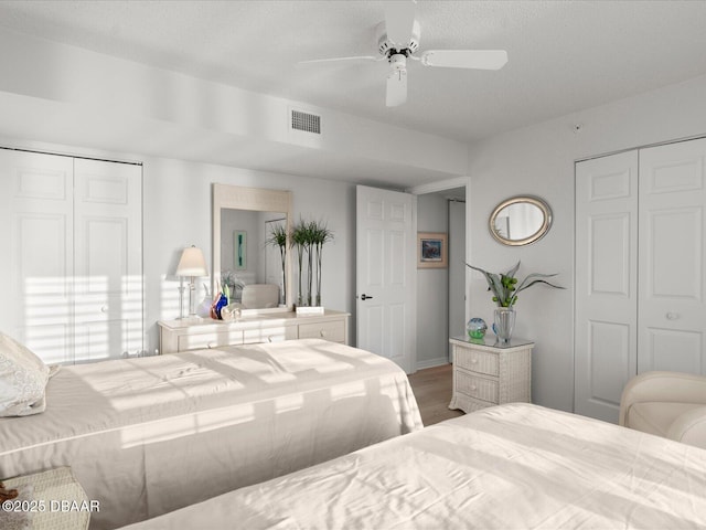 bedroom featuring visible vents, ceiling fan, and wood finished floors