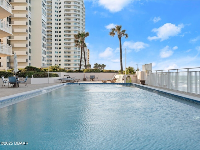 community pool featuring fence and a patio area