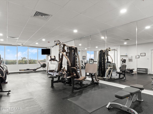 workout area featuring plenty of natural light, a paneled ceiling, and visible vents
