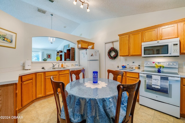 129 Rae Dr, Palm Coast, FL 32164 - kitchen featuring white appliances, lofted ceiling, light countertops, arched walkways, and a textured ceiling
