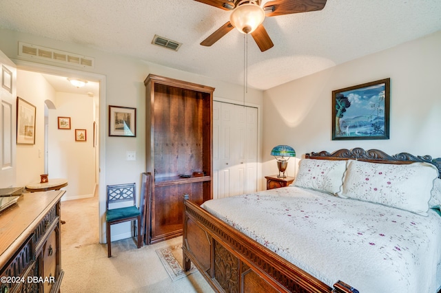 129 Rae Dr, Palm Coast, FL 32164 - bedroom with light colored carpet, a closet, a textured ceiling, and a ceiling fan